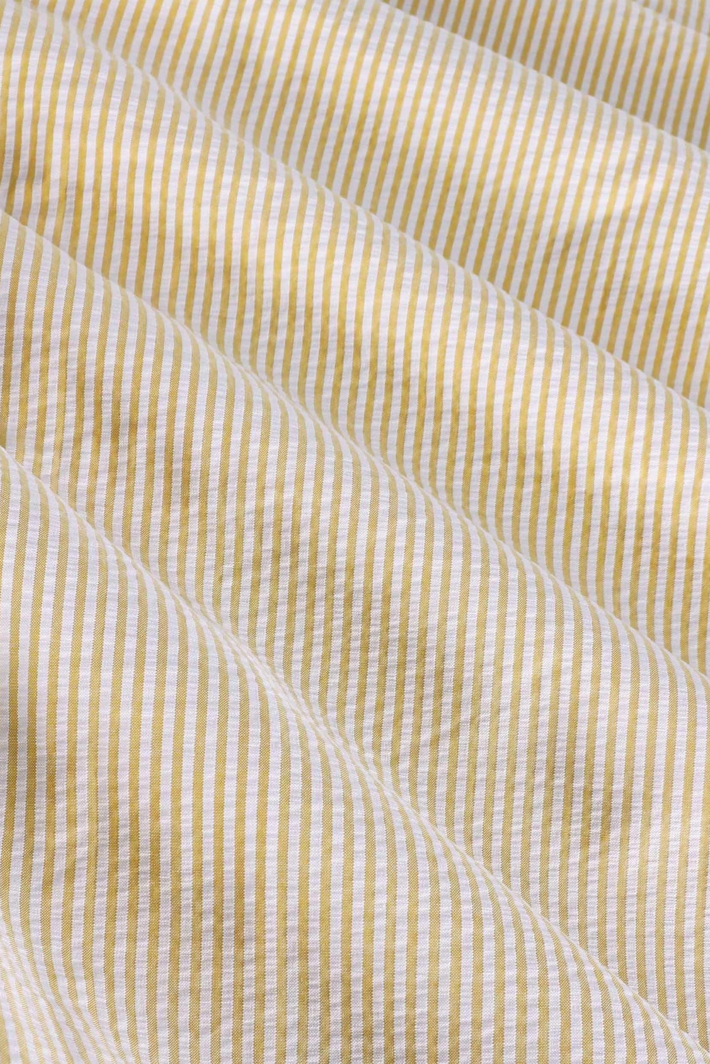 Close-up of yellow and white striped seersucker cotton fabric