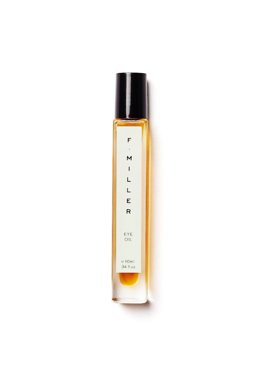 A bottle of Eye Oil with a label that reads 'F MILLER'. The bottle is transparent, showing a yellow-hued liquid inside, and has a black cap.