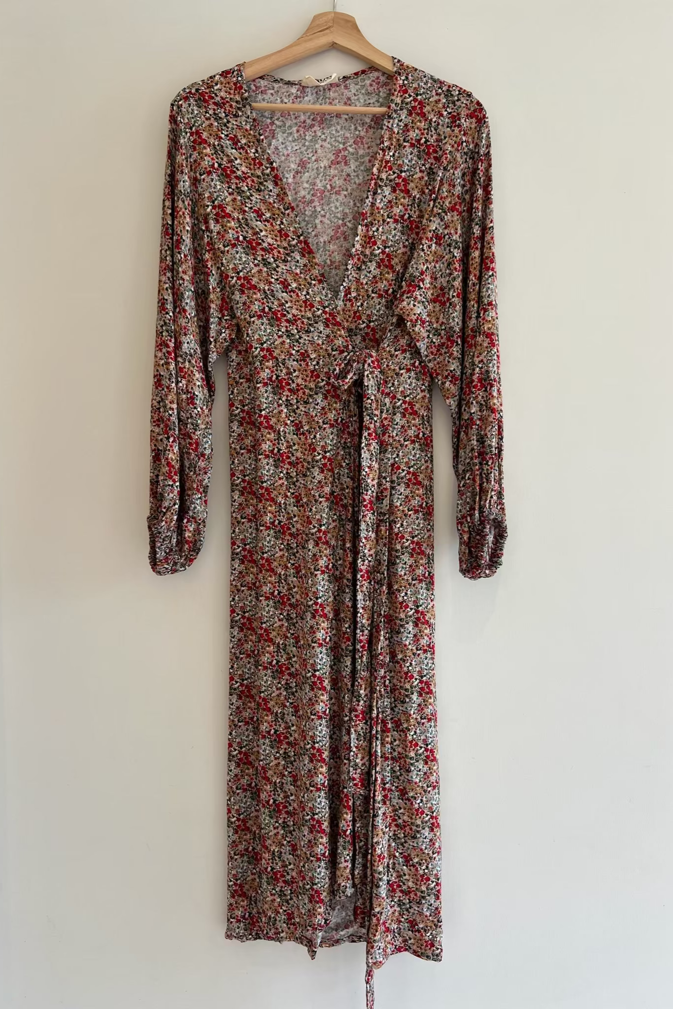 Floral dress on a hanger against a white background