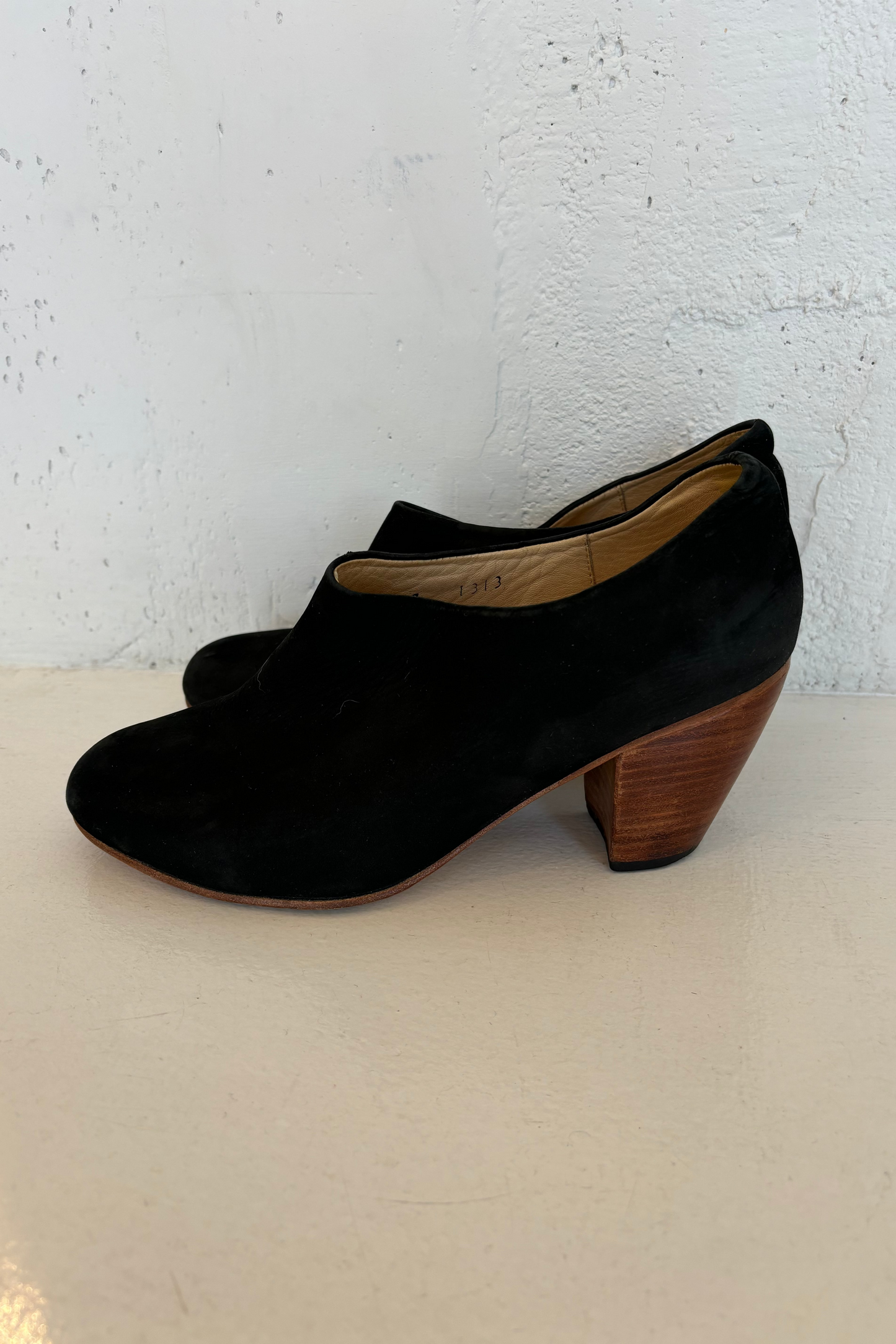 A black suede Dieppa Restrepo ankle boot with a wooden heel, displayed against a white background.
