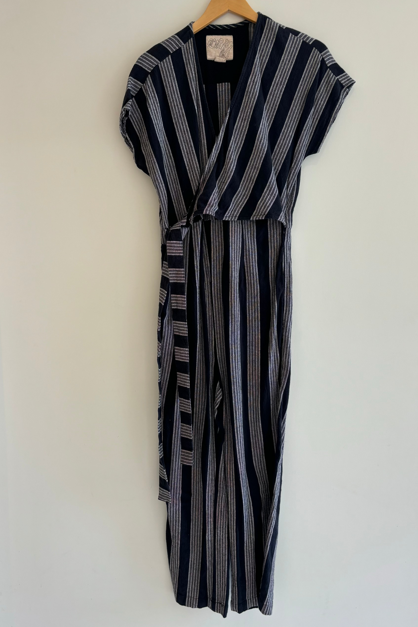 Black and white striped dress on a hanger against a white background