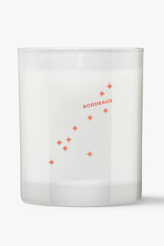 White candle with 'Bordeaux' and star designs on a white background