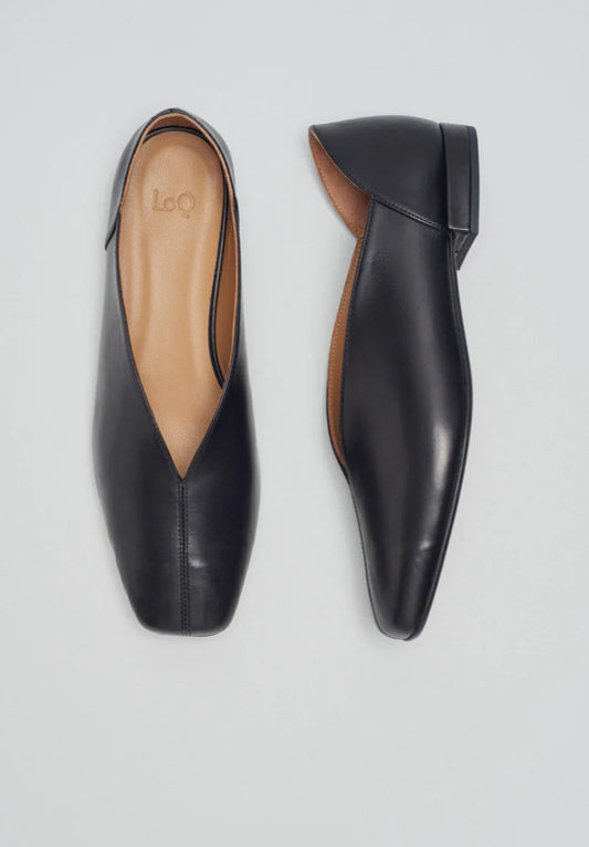 Pair of black leather  slipper shoes with a central seam, tulip shaped upper, squared-off toe and 3/4" heel on a light gray background