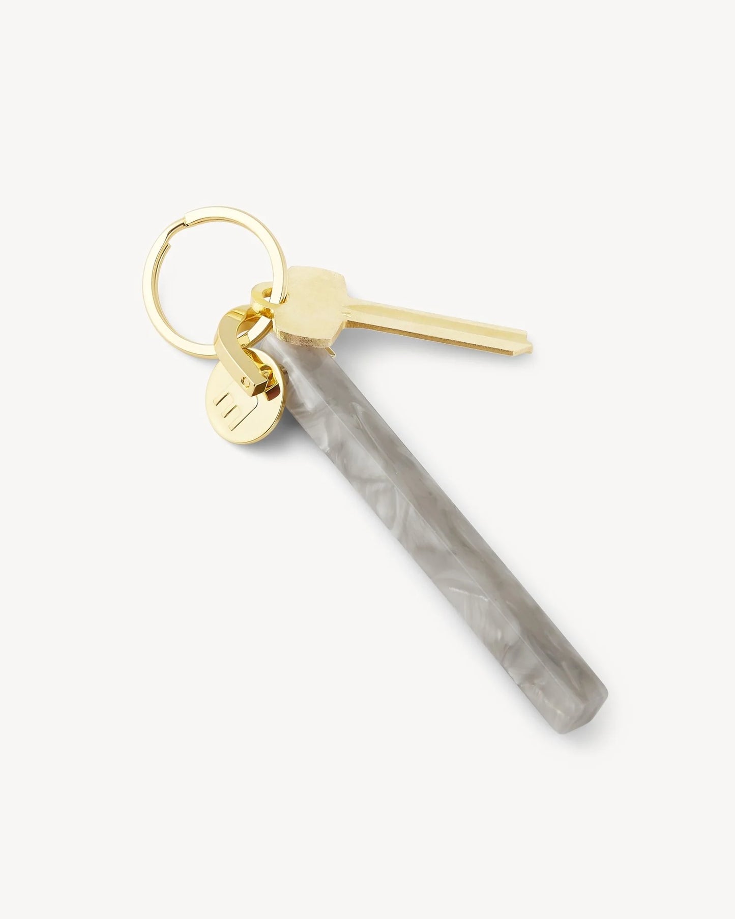 light grey marbled acetate keychain with gold hardware with M engraved on it