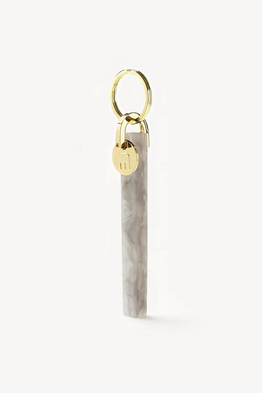 light grey marbled acetate keychain with gold hardware with M engraved on it