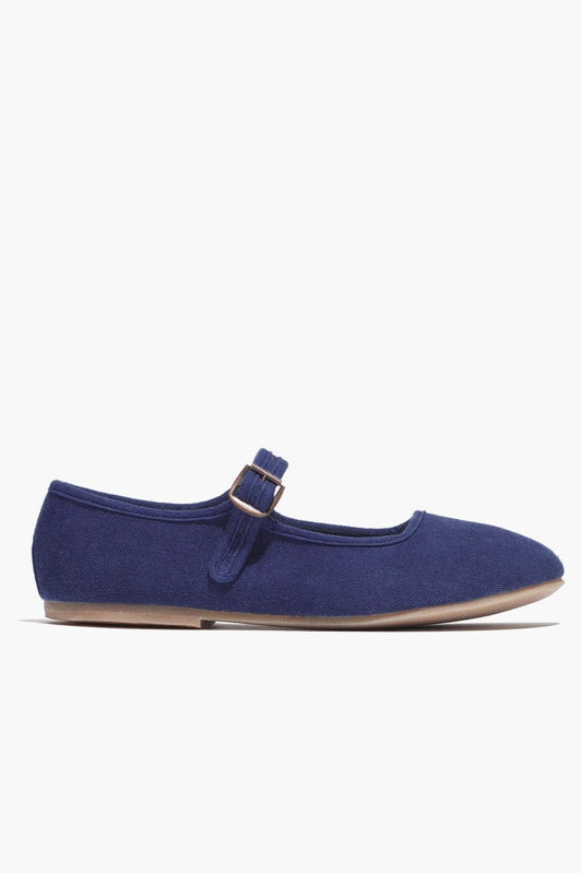 Navy blue flat shoe with a strap on a white background