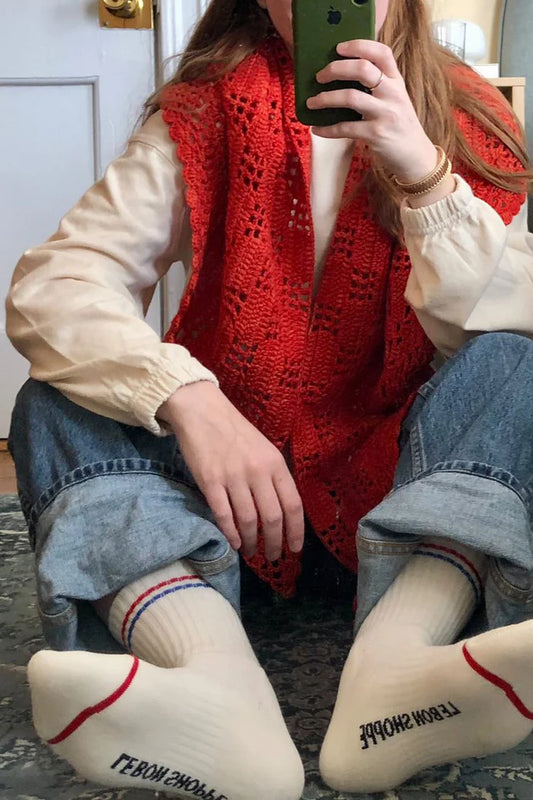 Le Bon Shoppe Boyfriend Socks in milk worn bare-footed in a mirror selfie with rolled light wash jeans and a red crochet vest, showing Le Bon Shoppe branding on the sole