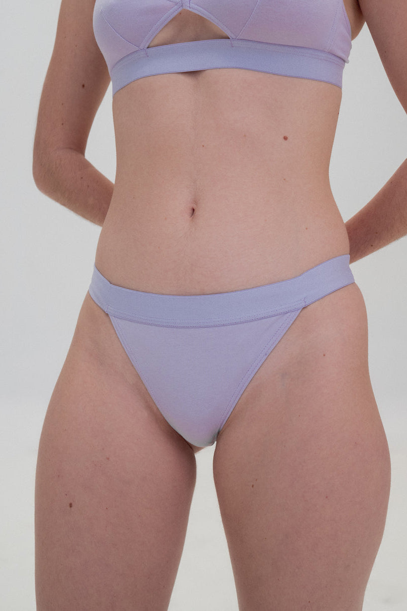 A pair of purple Triangle Briefs with a minimalist design, sitting comfortably around the hips, made from organic cotton.