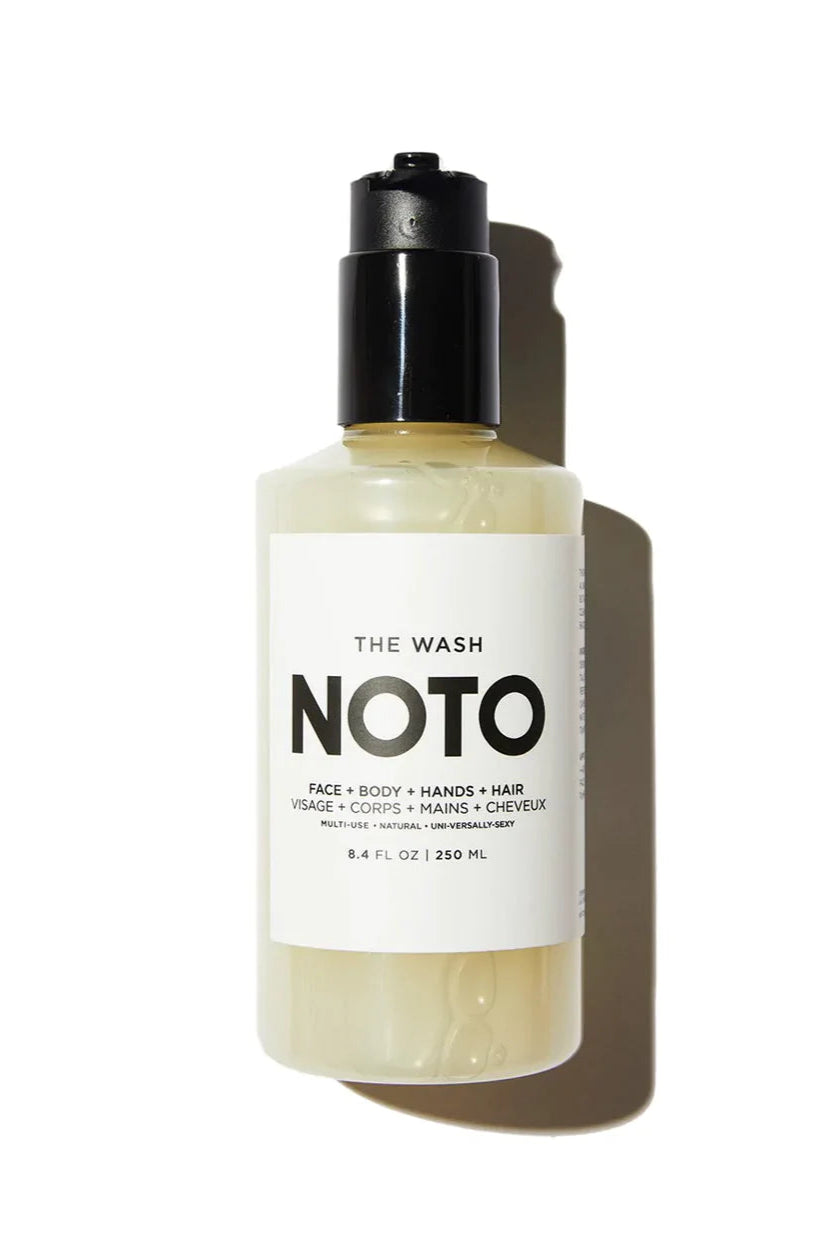 A clear bottle with a black pump labeled 'NOTO' containing a yellow liquid, presumably the all-in-one organic+natural gentle wash.
