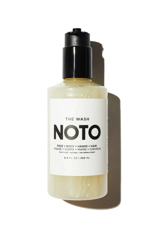 A clear bottle with a black pump labeled 'NOTO' containing a yellow liquid, presumably the all-in-one organic+natural gentle wash.