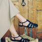 updated Fisherman sandal with buckle closure & three straps across the foot in woven black leather. 