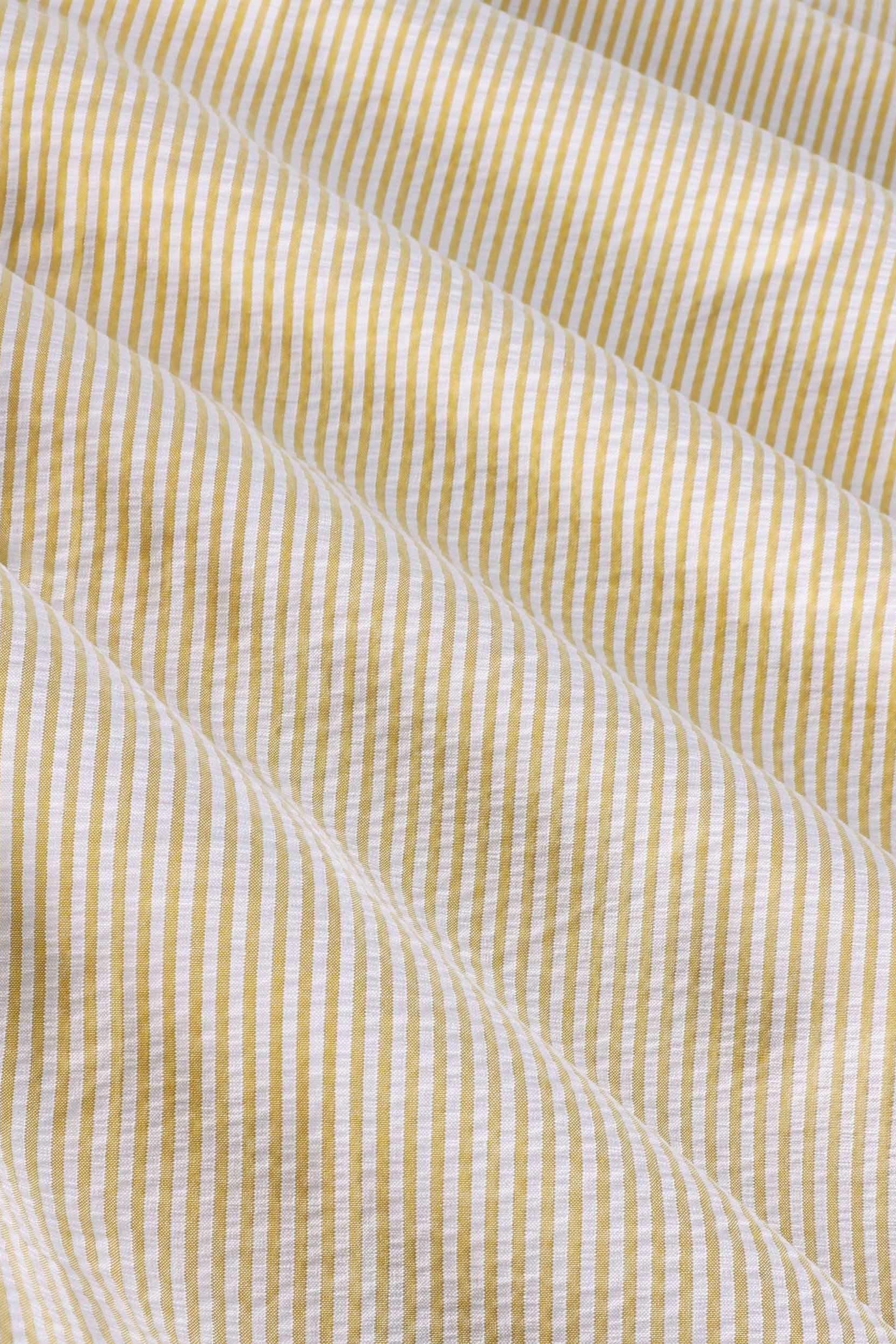 Close-up of yellow and white striped seersucker cotton fabric