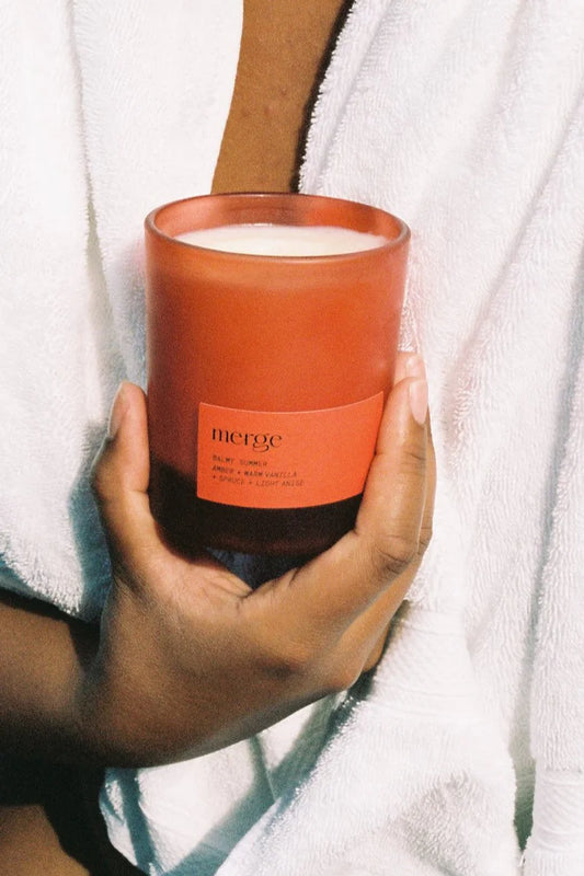natural scented soy candle hand poured in amber glass held in hands