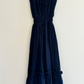 Navy blue dress on a hanger against a white background