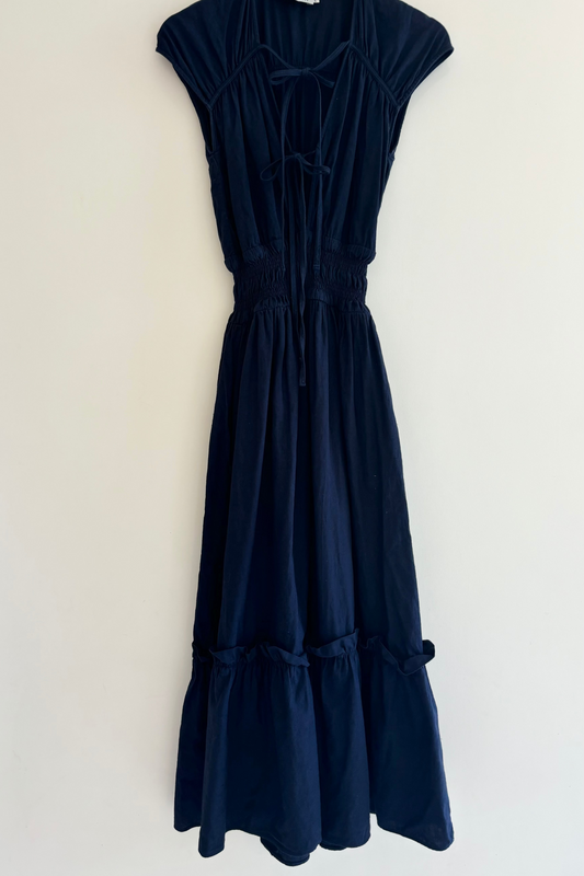 Navy blue dress on a hanger against a white background