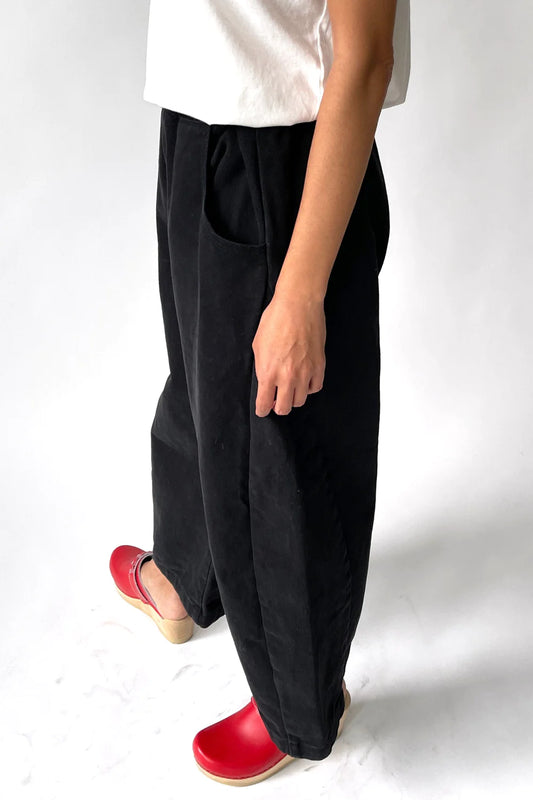 side view of black canvas arc pants showing side seam panels 