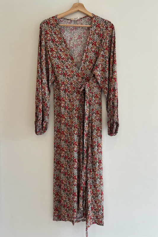Floral dress on a hanger against a white background
