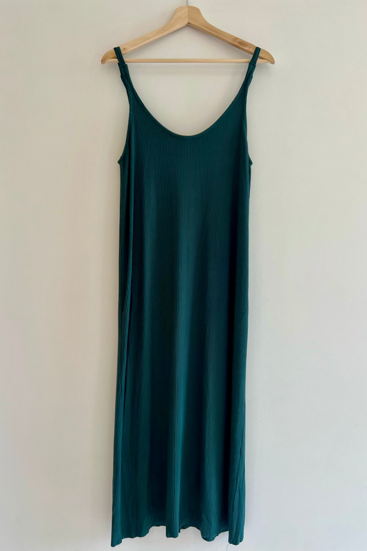 Green slip dress on a hanger against a white background