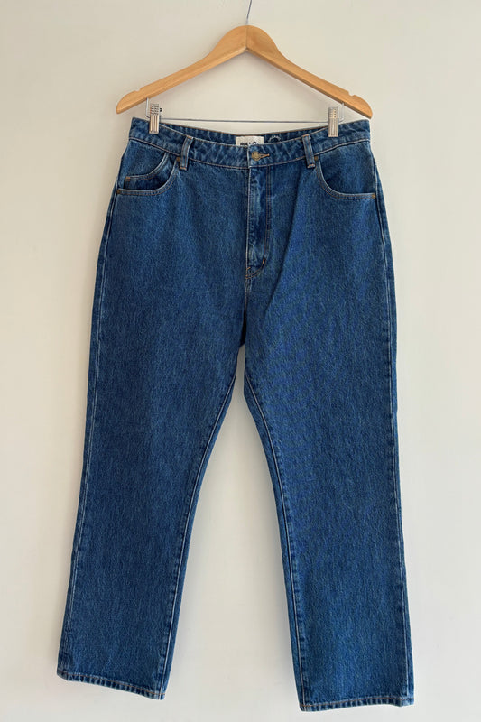 Blue jeans on a hanger against a light background