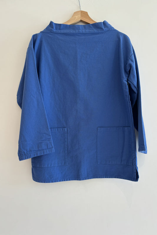 Blue jacket on a hanger against a white background