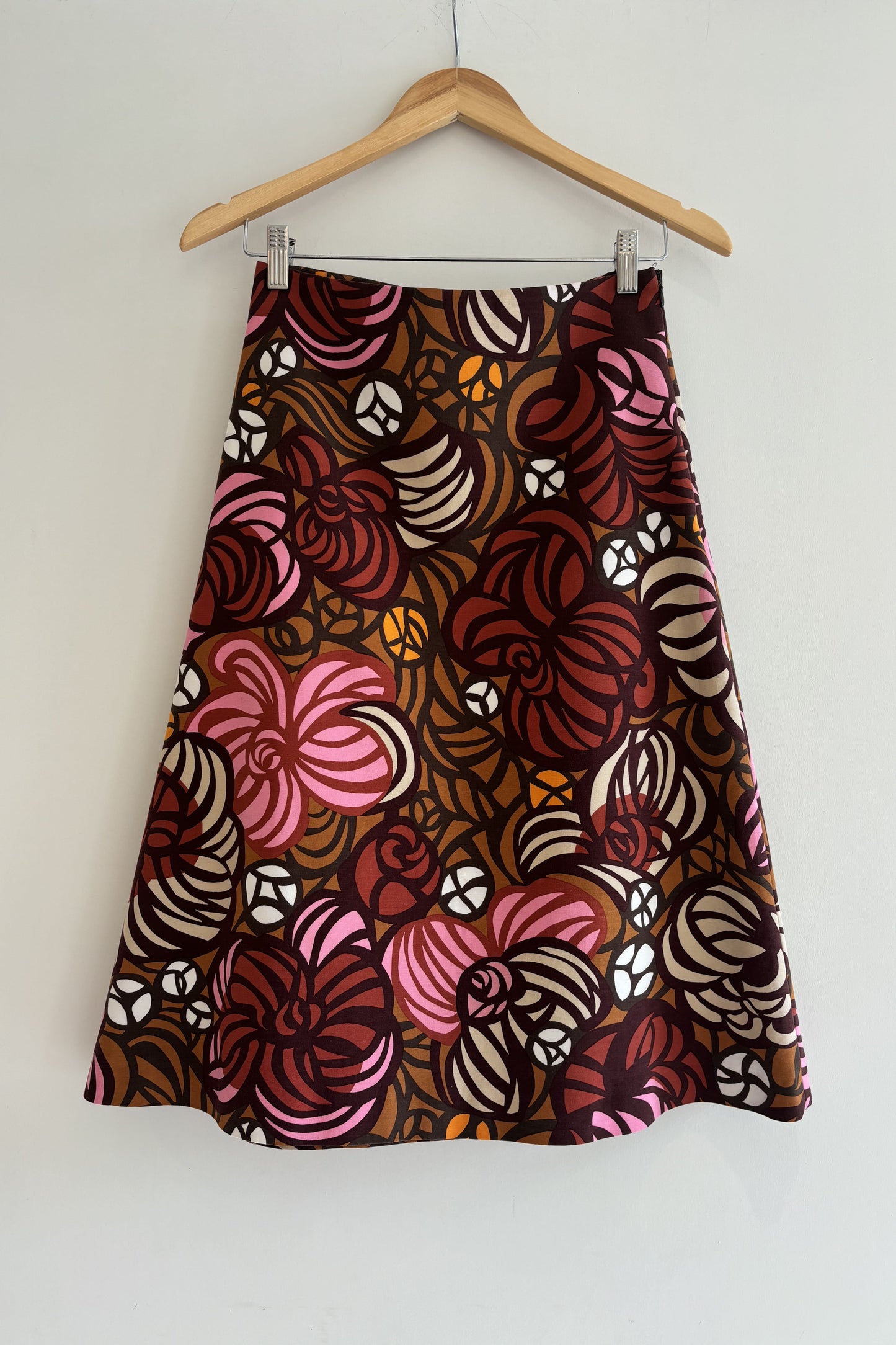 Skirt with a floral pattern on a hanger against a white background