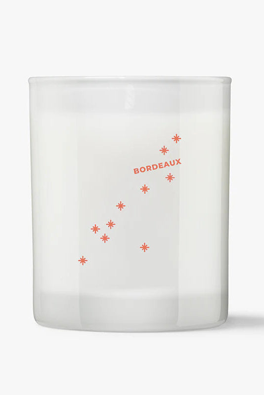 White candle with 'Bordeaux' and star designs on a white background