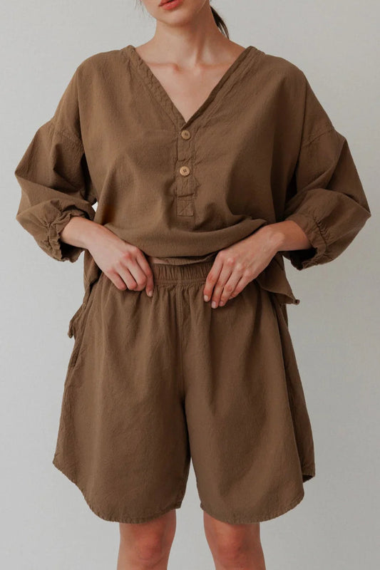 Person wearing a brown outfit with a plain background