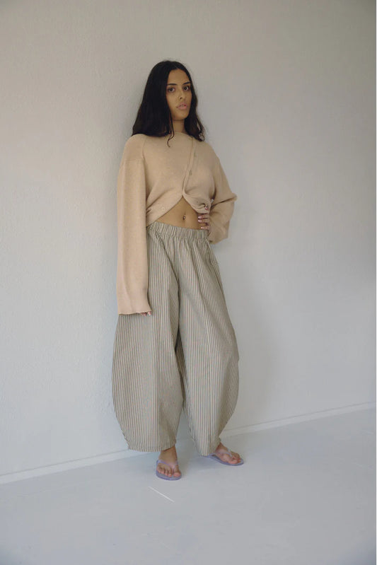 Bohème Goods Stripe Barrel Pant in sage and cream cotton stripe worn full length with a knotted blush knit cardigan and jelly sandals, showing relaxed barrel silhouette and elastic waist