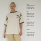 Bohème Goods Tourist Tee in cream size guide showing measurements for XS/S, M/L, L/XL and 2X/3X, styled with cream wide leg trousers