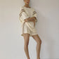 Bohème Goods Track Short in cream with brown side stripes styled as a matching set with the Bohème track tee, worn with jelly sandals against a white studio background
