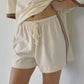 Close-up of Bohème Goods Track Short in cream showing cotton drawstring tie waist, elasticated waistband and brown vintage-inspired side stripe detail