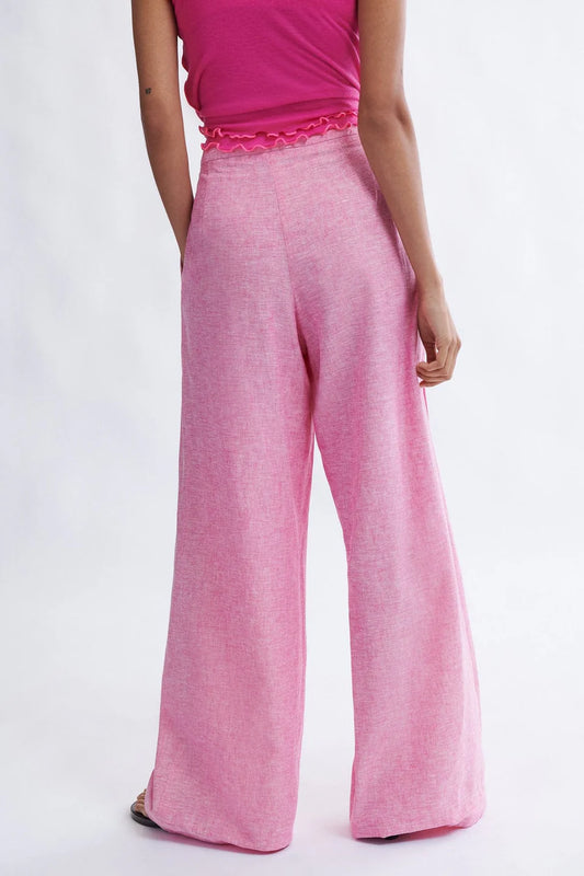 Woman wearing the Miranda Trouser in bubblegum linen-cotton blend by Eliza Faulkner — wide leg summer trousers at Ånde slow fashion store