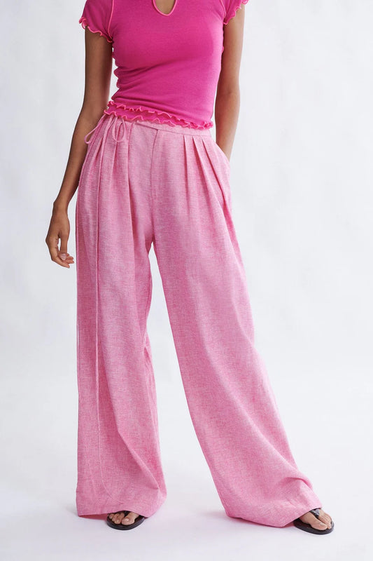Woman wearing the Miranda Trouser in Bubblegum Linen- cotton blend by Eliza Faulkner - wide leg summer trousers at Ånde slow fashion store 