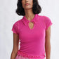 Woman wearing the Percy Polo Top in raspberry by Eliza Faulkner — lyocell wool blend, ethically made in Canada at Ånde