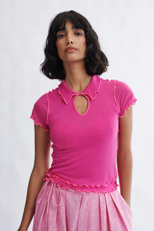 Woman wearing the Percy Polo Top in raspberry by Eliza Faulkner — lyocell wool blend, ethically made in Canada at Ånde