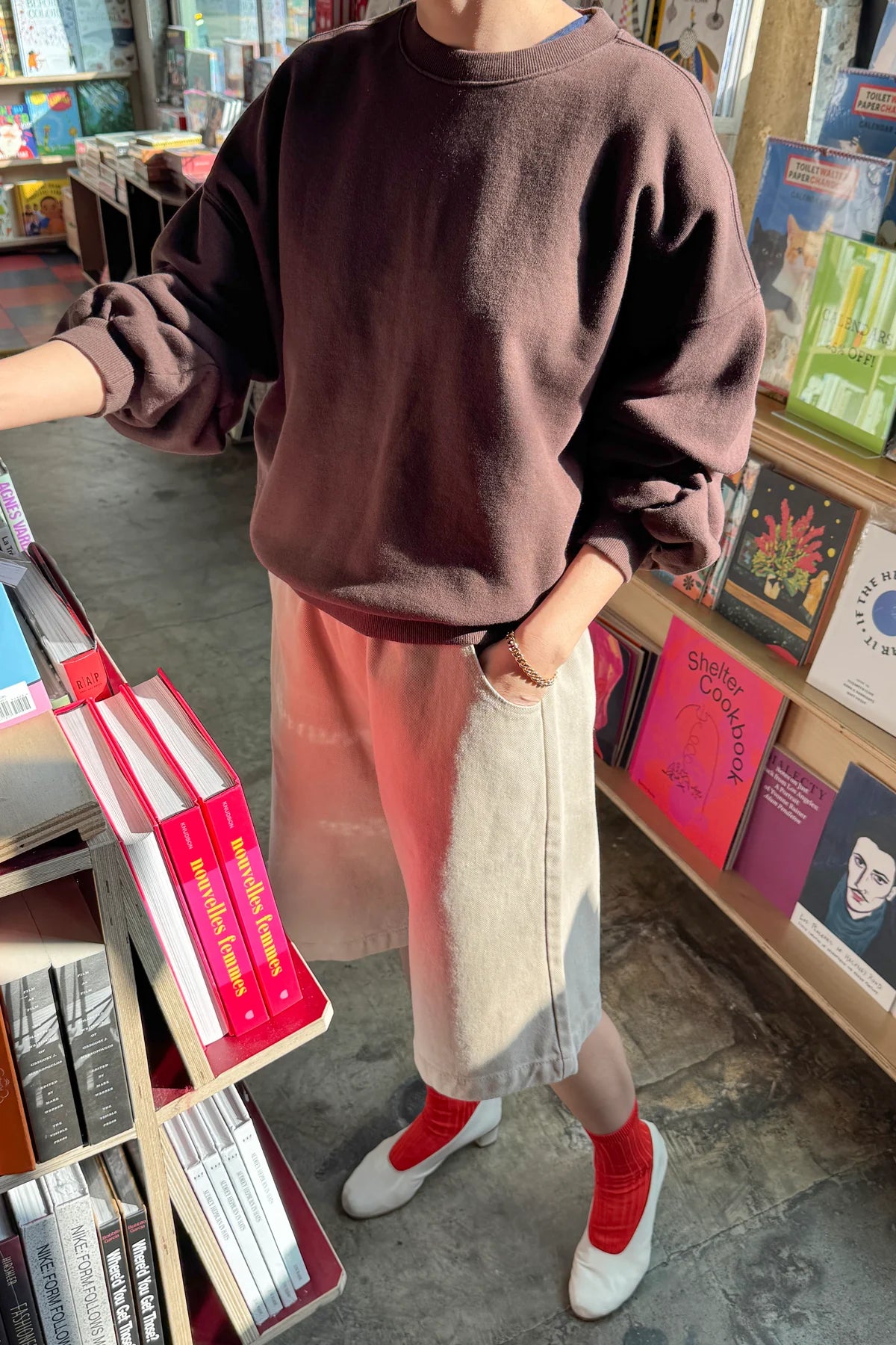 Le Bon Shoppe French Terry Core Sweatshirt in cocoa bean styled over a colour-block midi skirt with red ribbed socks and white heels in a bookstore setting