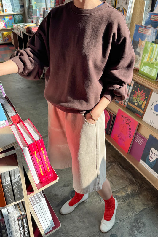 Le Bon Shoppe French Terry Core Sweatshirt in cocoa bean styled over a colour-block midi skirt with red ribbed socks and white heels in a bookstore setting
