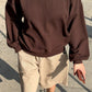 Le Bon Shoppe French Terry Core Sweatshirt in cocoa bean worn with taupe shorts, red ribbed socks and white shoes, shot on a sunny street