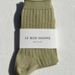Le Bon Shoppe Her Socks in avocado green, folded and banded with branded packaging label, displayed on a white linen surface