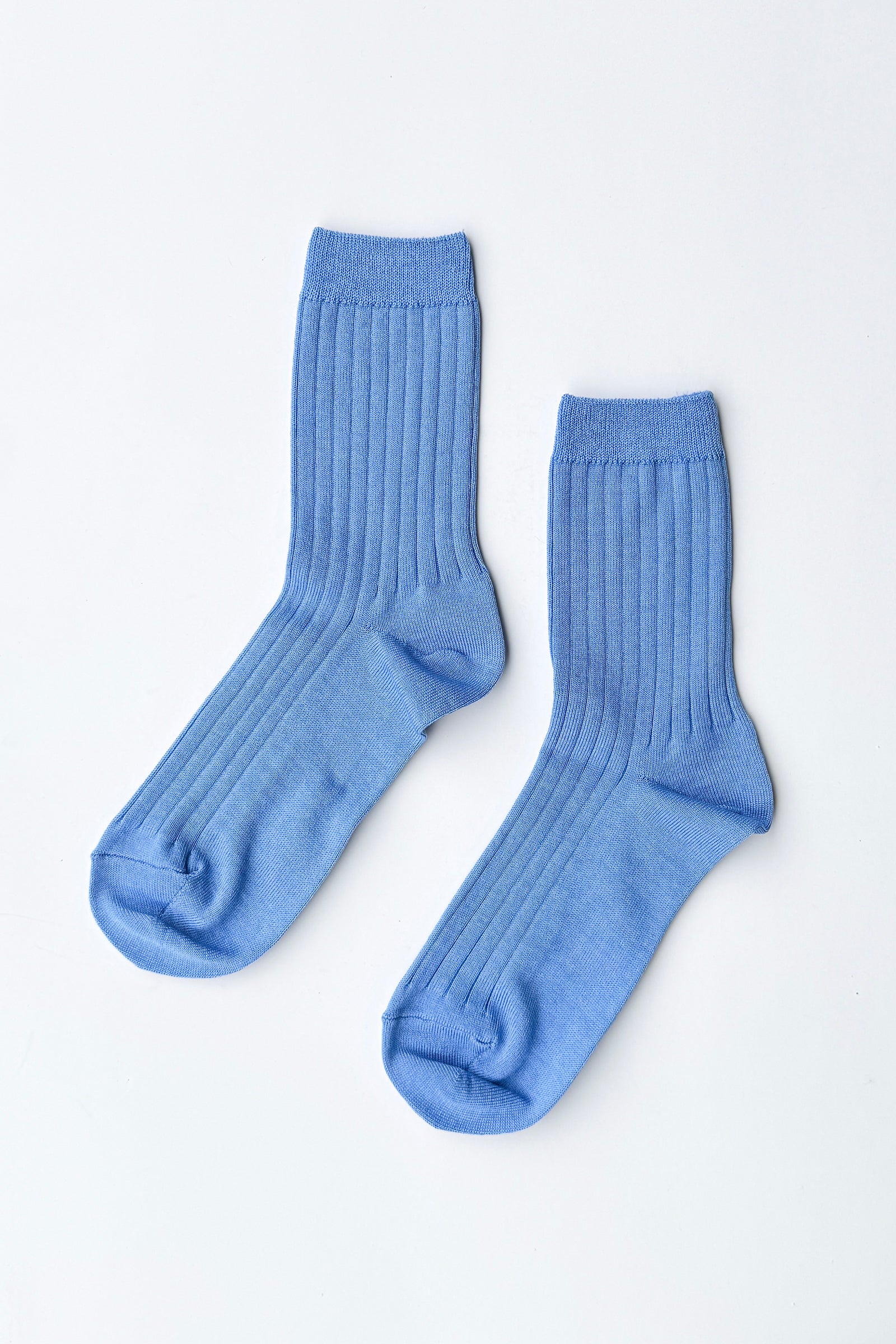 Pair of Le Bon Shoppe Her Socks in periwinkle laid flat on a white surface, showing ribbed cotton-blend texture and quarter-crew length