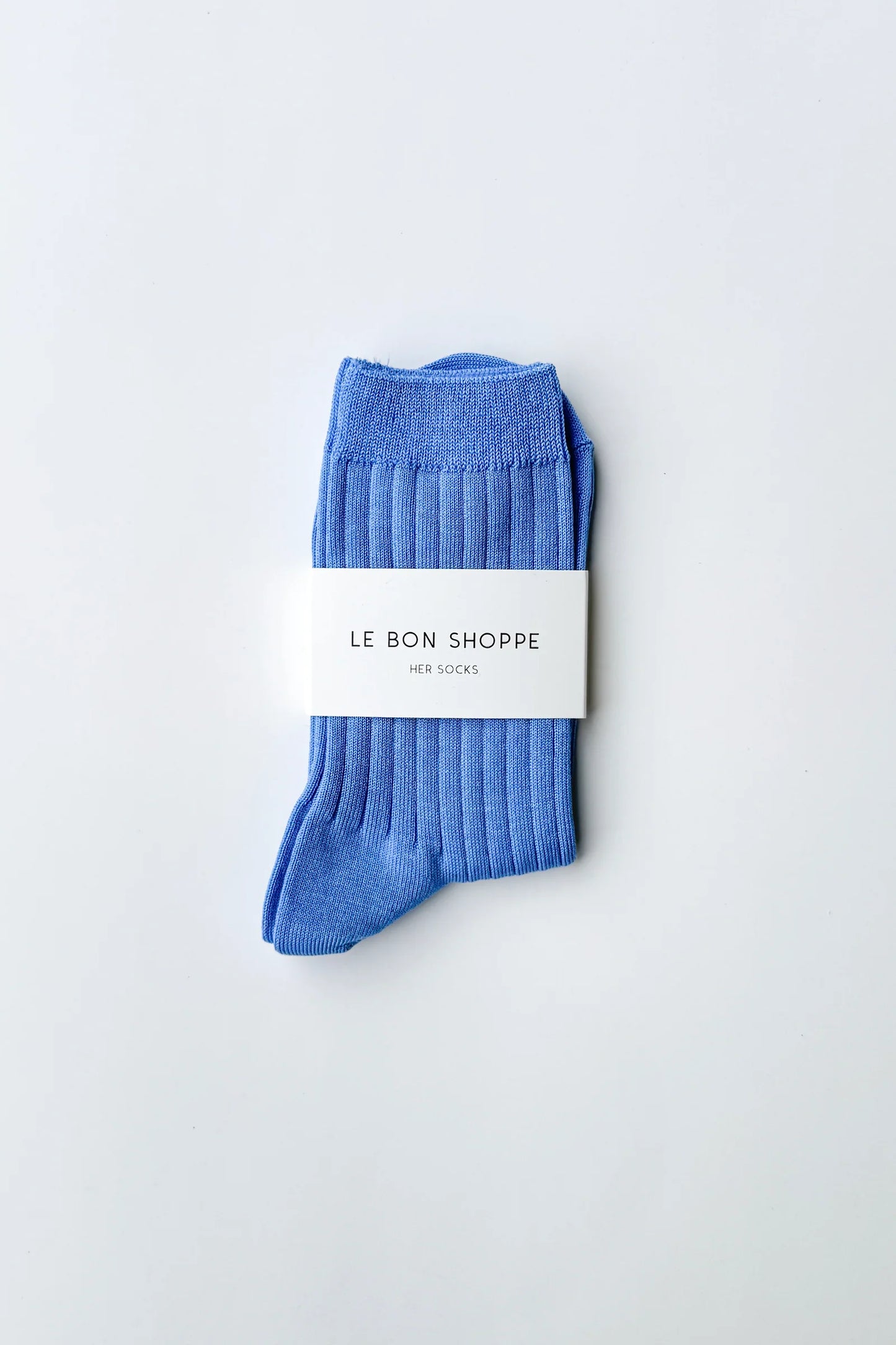 Le Bon Shoppe Her Socks in periwinkle folded and banded with branded Le Bon Shoppe packaging label, displayed on a light grey surface