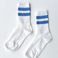 Pair of Le Bon Shoppe Her Varsity Socks in periwinkle laid flat on a white surface, showing white ribbed cotton-blend with periwinkle double stripe detail and quarter-crew length