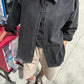 Le Bon Shoppe Theo Jacket in black denim worn open over a black tee and cream shorts with black ballet flats, shot on a city street