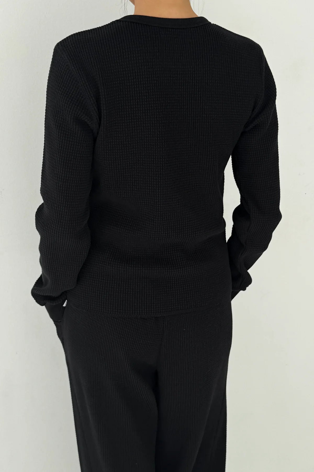 Back view of Le Bon Shoppe Waffle Fundamental Tee in true black showing heavyweight waffle cotton texture across back and sleeves, styled as a set with the Waffle Lo Pants
