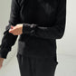 Close-up of Le Bon Shoppe Waffle Fundamental Tee in true black showing heavyweight waffle cotton texture and baby ribbed cuff detail, styled with matching Waffle Lo Pants