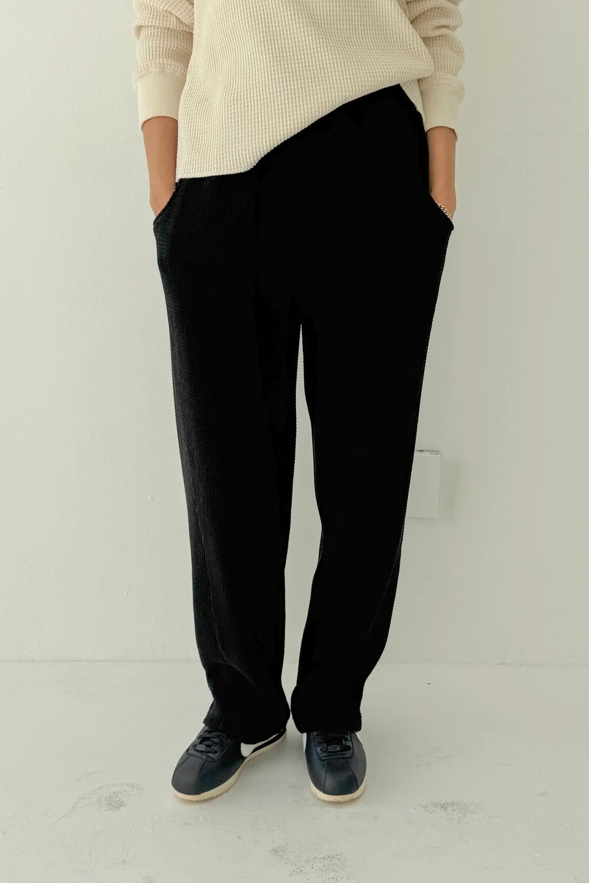 Le Bon Shoppe Waffle Lo Pants in true black full length front view showing relaxed wide leg silhouette, elastic waist and front pockets, styled with cream Waffle Fundamental Tee and navy sneakers